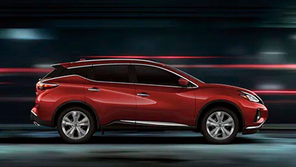 2023 Nissan Murano shown in profile driving down a street at night illustrating performance. | Bedford Nissan in Bedford OH